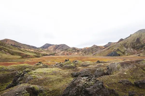 Landmannalaugar 'daki İzlanda gökkuşağı dağları volkanik rhyolit, yosun ve kül renginde gerçeküstü renklerle parıldıyor ve doğa kendi soyut başyapıtını resmediyor. Gökkuşağında yürüyorum.