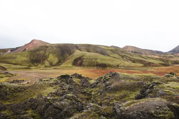 Landmannalaugar 'daki İzlanda gökkuşağı dağları volkanik rhyolit, yosun ve kül renginde gerçeküstü renklerle parıldıyor ve doğa kendi soyut başyapıtını resmediyor. Gökkuşağında yürüyorum.