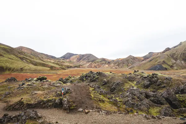 Landmannalaugar 'daki İzlanda gökkuşağı dağları volkanik rhyolit, yosun ve kül renginde gerçeküstü renklerle parıldıyor ve doğa kendi soyut başyapıtını resmediyor. Gökkuşağında yürüyorum.