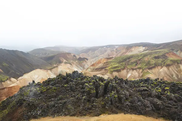 Renkli rhyolite dağlarının geniş manzarası ve İzlanda, Landmannalaugar 'da örülmüş bir nehir yatağı. İskoçya 'nın kalbinde gerçek üstü ve el değmemiş volkanik bir manzara..