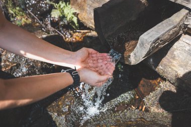 Yürüyüşe çıkmış bir kız susuzluğunu Beskydy Dağları 'ndan gelen bir dereden gelen tatlı suyla gideriyor. Spor faaliyetlerinin bir parçası olarak su kaybı