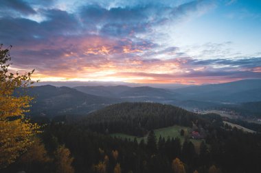 Renkli günbatımında Beskydy Dağları. Sonbahar ormanı, yuvarlanan tepeler ve huzurlu vadi özgürlüğü, macerayı ve sakin açık hava yaşam tarzını çağrıştırıyor..
