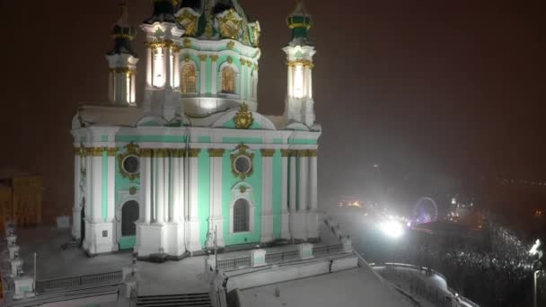 冬の聖アンドリュース教会キエフ市は雪で覆われています プールエリアの空中ビュー 旧住宅街を見下ろす建物 キエフ ウクライナのポドルとセント アンドリュース教会の空中ビュー — ストック動画