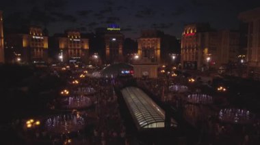 Independence Square. Kiev Kyiv. Ukraine. Aerial view of the fountains. Evening. People walk around the square. Building. On the road there are cars. Singing Fountains