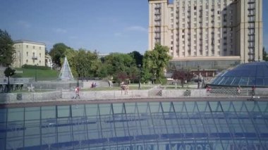 Independence Square. Kiev Kyiv. Ukraine. Aerial view of the fountains. Evening. People walk around the square. Building. On the road there are cars. Singing Fountains