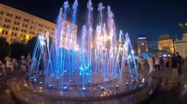 Independence Square. Kiev Kyiv. Ukraine. Aerial view of the fountains. Evening. People walk around the square. Building. On the road there are cars. Singing Fountains