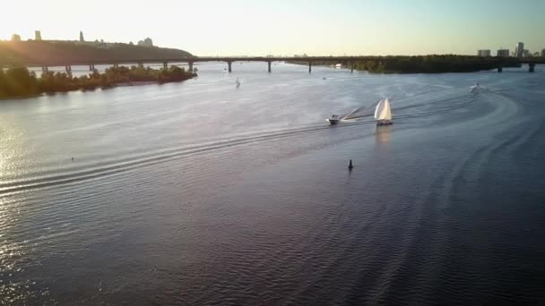 从空中俯瞰正在移动的渔船海洋 日落时带垂钓者在第聂伯河上航行的汽船 城市湖上的桥景观 — 图库视频影像