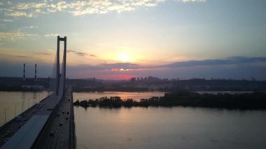 Aerial photography of the south bridge, Kiev city. Ukraine. Dnieper river, the bridge crosses the river. Cityscape aerial view of a river bridge at night The movement of cars and trains on the bridge.