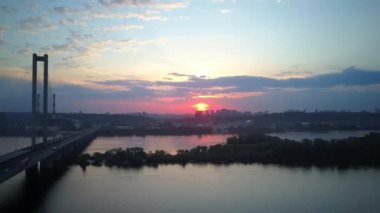 Kiev şehrinin güney köprüsünün hava fotoğrafları. Ukrayna. Dinyeper nehri, köprü nehri geçer. Geceleri nehir köprüsünün havadan görünüşü köprüdeki araba ve trenlerin hareketleri..