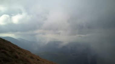 4K .Aerial beautiful l landscape . Smooth fly over mountains clouds ,ridges and hills. Blue sky over the mountains. Flying through the clouds and above the mountains, epic natural landscape .
