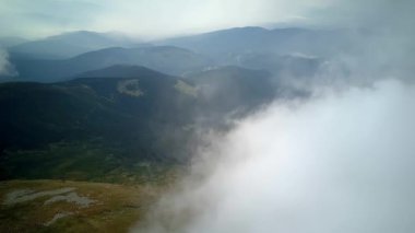 4K .Aerial beautiful l landscape . Smooth fly over mountains clouds ,ridges and hills. Blue sky over the mountains. Flying through the clouds and above the mountains, epic natural landscape .
