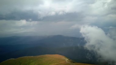 4K .Aerial beautiful l landscape . Smooth fly over mountains clouds ,ridges and hills. Blue sky over the mountains. Flying through the clouds and above the mountains, epic natural landscape .