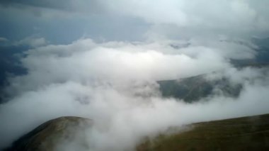 4K .Aerial beautiful l landscape . Smooth fly over mountains clouds ,ridges and hills. Blue sky over the mountains. Flying through the clouds and above the mountains, epic natural landscape .