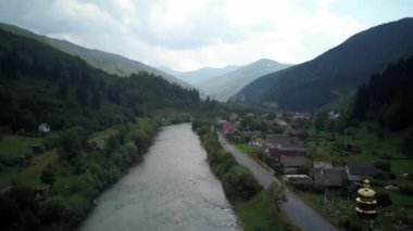 Aerial view to Mountain river flowing over the rocks between the trees in dense forest. on the mountain river in pine forest. Muddy dirty water flows through the rocks