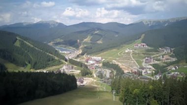 Scenic aerial view of mountains covered with forest, Ukraine. High quality 4k footage, Aerial. Rear Flight over summer bright mountain hills with trees, 