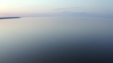 Vast blue lake background with moderate waves looking straight down. big blue lake among green prairie at the sunny summer day, Aerial Drone Flight Footage Beautiful Sky and Water in sunset soft light