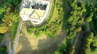 Olesko Palace from the air. Reserve. Summer park on the hills. Ukraine. Aerial shot Village Olesk castle. Ukraine. Aerial view of the Olesky Castle and residential neighborhoods near it
