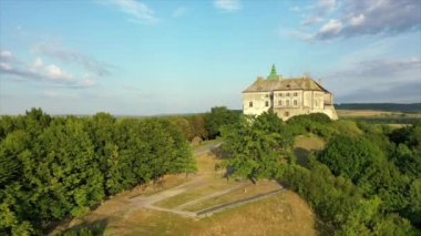 Olesko Palace from the air. Reserve. Summer park on the hills. Ukraine. Aerial shot Village Olesk castle. Ukraine. Aerial view of the Olesky Castle and residential neighborhoods near it