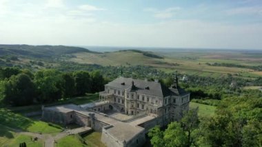 Old castle Podgortsy, Ukraine. View of the castle from above, aerial view from a drone. Podgoretsky castle. On the horizon is an old church. Architectural structure of medieval forest on a hill