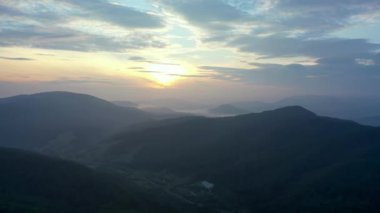 Gün batımında dağların manzarası. Karpat dağlarının panoramik manzarası yazın günbatımında güzel altın bir akşam ışığında parlıyordu..