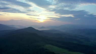 Gün batımında dağların manzarası. Karpat dağlarının panoramik manzarası yazın günbatımında güzel altın bir akşam ışığında parlıyordu..