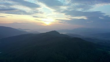 Gün batımında dağların manzarası. Karpat dağlarının panoramik manzarası yazın günbatımında güzel altın bir akşam ışığında parlıyordu..