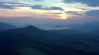 Gün batımında dağların manzarası. Karpat dağlarının panoramik manzarası yazın günbatımında güzel altın bir akşam ışığında parlıyordu..