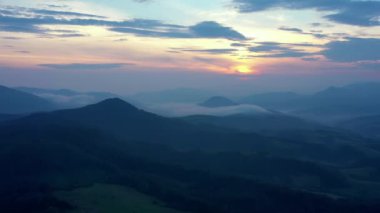 Gün batımında dağların manzarası. Karpat dağlarının panoramik manzarası yazın günbatımında güzel altın bir akşam ışığında parlıyordu..