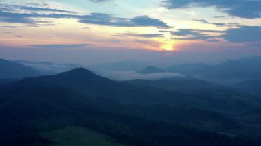 Gün batımında dağların manzarası. Karpat dağlarının panoramik manzarası yazın günbatımında güzel altın bir akşam ışığında parlıyordu..