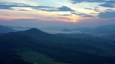 Gün batımında dağların manzarası. Karpat dağlarının panoramik manzarası yazın günbatımında güzel altın bir akşam ışığında parlıyordu..