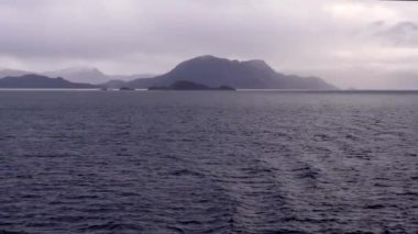 Norveç 'te pitoresk fiyort boyunca dolaşmak, gemiden manzara, Kuzey Norveç' te Senja kıyısı bir teknenin arkasından manzara. Kuzey Norveç 'te Senja' nın kıyıları bir teknenin arkasından görülüyor..