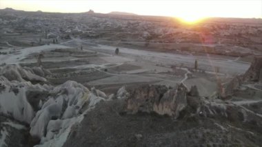 Türkiye 'nin Kapadokya kentindeki volkanik kaya oluşumları. Kayalık vadi manzarası, ilerleyen hava aracı görüntüsü perili baca manzarasını izlemek için kamera aşağı eğilerek uçuyor., 
