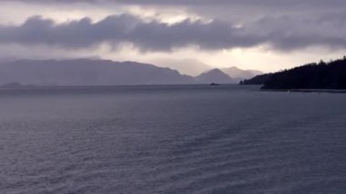 Norveç 'te pitoresk fiyort boyunca dolaşmak, gemiden manzara, Kuzey Norveç' te Senja kıyısı bir teknenin arkasından manzara. Kuzey Norveç 'te Senja' nın kıyıları bir teknenin arkasından görülüyor..