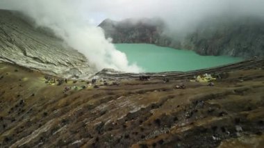 Krater asit gölü Kawah Ijen 'in, sülfür madeninin olduğu dramatik hava manzarası. Sülfür gazı, duman, madenciler. Doğu Java Endonezya 'daki dağ manzarası Ijen volkanı kompleks stratovolkanları grubu.