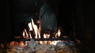 Şömine. Rahatlatıcı Şömine. Yakacak odun. Bir kır evinin alevleri. Sıcaklık ve ev konforu. Toprak. Şöminede ateş yanıyor. Şöminede güzel bir ateş, yanan bir odun. 