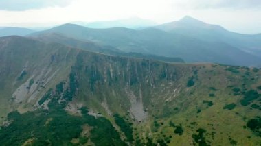 Ukrayna, ormanla kaplı dağların manzaralı manzarası. Yüksek kalite 4K görüntü, Aerial. Yaz boyunca arka uçuş Ağaçlarla kaplı parlak dağ tepeleri, Dağ SpITSI CARPATHİANS