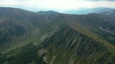 Ukrayna, ormanla kaplı dağların manzaralı manzarası. Yüksek kalite 4K görüntü, Aerial. Yaz boyunca arka uçuş Ağaçlarla kaplı parlak dağ tepeleri, Dağ SpITSI CARPATHİANS