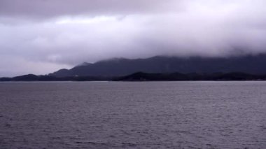 Norveç 'te pitoresk fiyort boyunca dolaşmak, gemiden manzara, Kuzey Norveç' te Senja kıyısı bir teknenin arkasından manzara. Kuzey Norveç 'te Senja' nın kıyıları bir teknenin arkasından görülüyor..