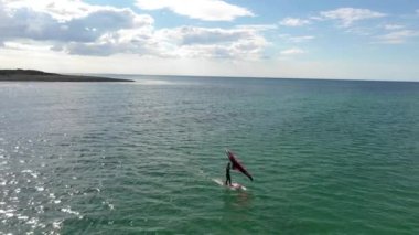 Formda sporcuların hava aracı videosu tropik egzotik körfez, Modern Su Sporları 'nda hidro folyo kanat sörfü yapıyor. Kanadı ve rüzgarın gücünü kullanarak okyanusta hidrofolyo sürmek..
