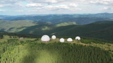 Karpat dağlarındaki terk edilmiş radar istasyonu Pamir Ukrayna 'daki Karpatlar' daki Pamir dağının tepesindeki araştırma istasyonu. Büyük beyaz balonlar, köknar ağaçları arasında dağlarda dizayn edilir.. 