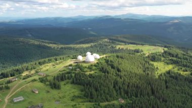 Karpat dağlarındaki terk edilmiş radar istasyonu Pamir Ukrayna 'daki Karpatlar' daki Pamir dağının tepesindeki araştırma istasyonu. Büyük beyaz balonlar, köknar ağaçları arasında dağlarda dizayn edilir.. 