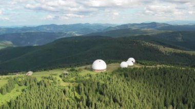 Dağların havadan görüntüsü. Dağlar, tepeler, uçurumlar, kayalar, çıkıntılar, manzara, yeşil çimenler, gökyüzü, bulutlar, doğa, işlenmemiş doğa, insansız hava aracı videosu. Dağlık bölgede hareket, 