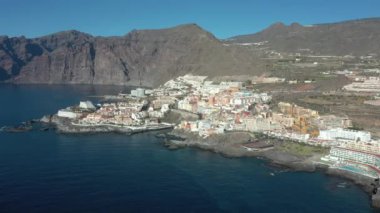 Sahil şeridinde kayalık kahverengi uçurumlar olan sakin bir okyanus manzarası. Los Gigantes Tenerife.Kanarya Adaları, okyanus dalgalarının üst hava manzarası kayaların arka planına, Tenerife 'ye, Kanarya Adalarına, İspanya' ya, Atlantik 'e çarpar. 