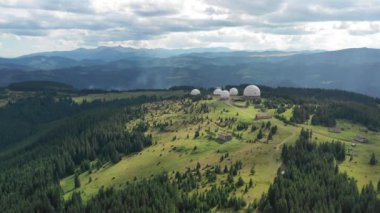 Karpat dağlarındaki terk edilmiş radar istasyonu Pamir Ukrayna 'daki Karpatlar' daki Pamir dağının tepesindeki araştırma istasyonu. Büyük beyaz balonlar, köknar ağaçları arasında dağlarda dizayn edilir.. 