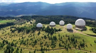 Karpat dağlarındaki terk edilmiş radar istasyonu Pamir Ukrayna 'daki Karpatlar' daki Pamir dağının tepesindeki araştırma istasyonu. Büyük beyaz balonlar, köknar ağaçları arasında dağlarda dizayn edilir.. 