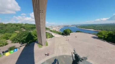  FPV drone, Reunion Arch, Kyiv: Halkın Dostluk Kemeri ve Volodymyr Hill Köprüsü. Kiev 'deki parkın ve yaya köprüsünün manzarası. Parktaki insanlar ve yeşil ağaçlar. Drone Video. Ukrayna. Avrupa