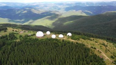 Karpat dağlarındaki terk edilmiş radar istasyonu Pamir Ukrayna 'daki Karpatlar' daki Pamir dağının tepesindeki araştırma istasyonu. Büyük beyaz balonlar, köknar ağaçları arasında dağlarda dizayn edilir.. 