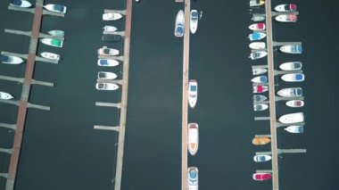 Yatlar, sürat tekneleri ve tekneler için park yeri olan güzel büyük bir koy. Yaz. Yatın sinematik hava görüntüsü, güzel körfezdeki iskeleye park etmiş birçok yelkenlinin dikey hava görüntüsü.