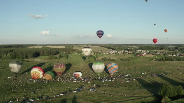 气球飘过天空 气球节 膨胀的大气球 几个气球躺在地上 空中看到一个热气球在树上飞舞 这是一个五彩缤纷的气球节 — 图库视频影像