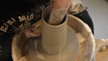 Eller çömlekçi çarkında dönen çömlekçi çarkında dönen çömlekçi çarkında çalışan elleri kapatır ve süngeriyle nemlendirir. Potter çömlekçinin çarkındaki çömlek aletleriyle killi ürünü şekillendirir. 